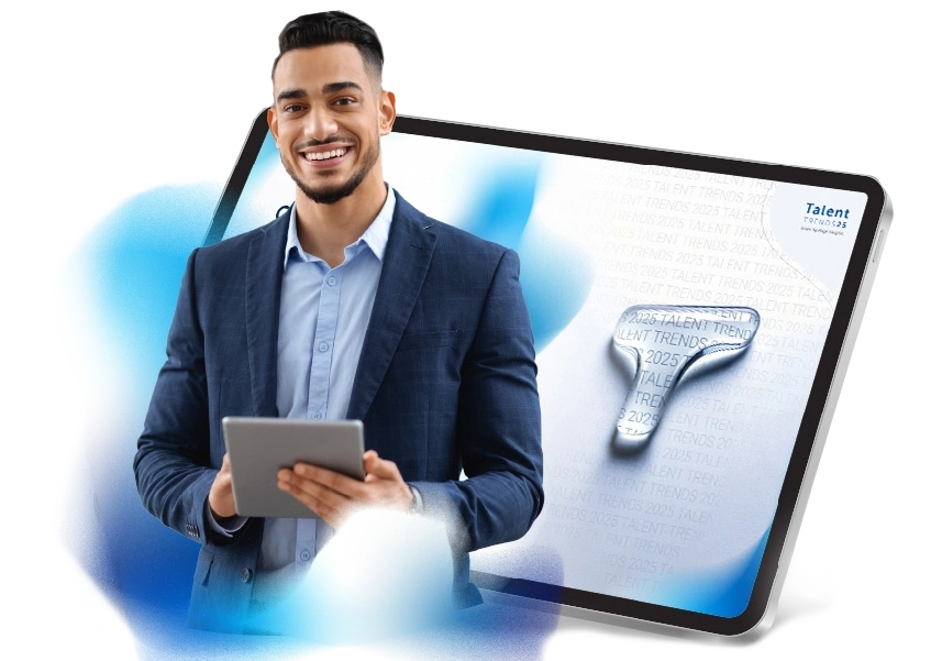 Un homme souriant avec une tablette entre les mains se tient debout devant l'image d'une tablette où apparaît la première page de Talent Trends.