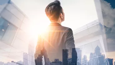 Un individu regarde vers le ciel devant une ville moderne.