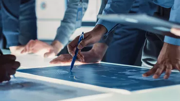 Personnes discutant autour d'une table avec des plans.