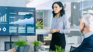 Présentation de graphiques financiers dans une salle de réunion moderne.