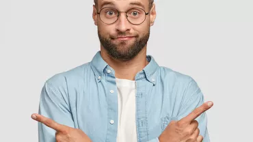 Personne en chemise bleue pointant dans deux directions.