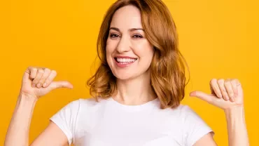 Personne souriante en t-shirt blanc sur fond jaune.