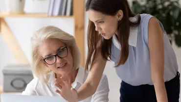 Personnes utilisant un ordinateur portable ensemble dans un bureau.