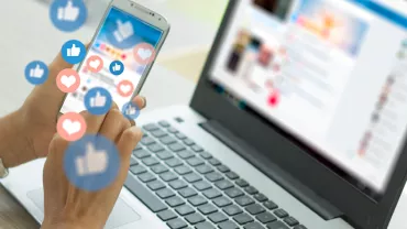 Personne utilisant un smartphone avec des icônes de réseaux sociaux