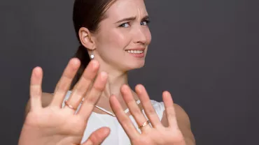 Personne levant les mains avec une expression incertaine.