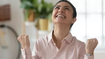 Personne souriante, les poings levés avec joie.