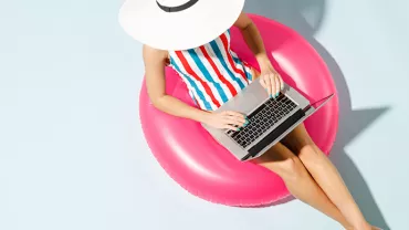 Personne utilisant un ordinateur portable sur une bouée rose.