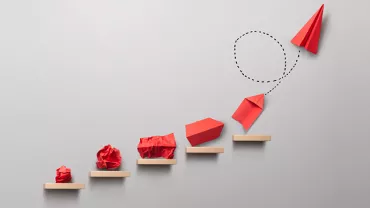 Progression d'objets en papier rouge sur des marches.