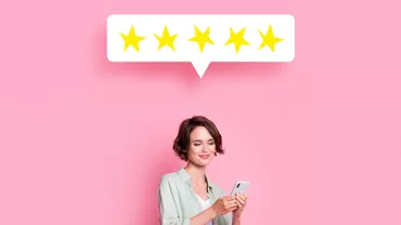 Personne lisant un message de cinq étoiles sur un téléphone.