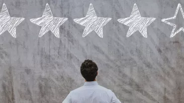 Personne observant un mur avec quatre étoiles remplies et une étoile vide.