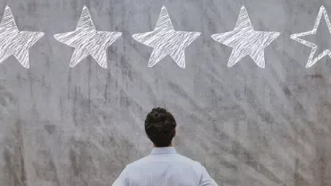 Personne observant un mur avec quatre étoiles remplies et une étoile vide.
