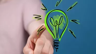 Personne pointant vers une ampoule verte dessinée.