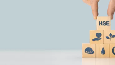 Main empilant des cubes en bois avec des icônes de santé et sécurité.