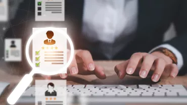 Personne tapant sur un clavier avec une loupe et des icônes de profil.