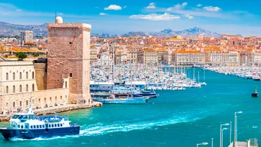 Vue du Vieux-Port de Marseille avec des bateaux et des bâtiments historiques.