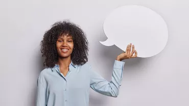 Personne souriante tenant une bulle de discours blanche.