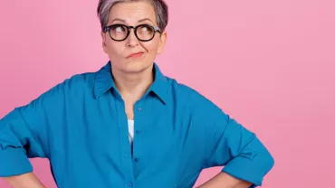 Personne avec des lunettes sur fond rose.