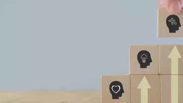 Blocs en bois avec icônes de têtes et flèches ascendantes.