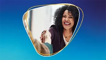 Une femme souriante serrant la main d'une autre personne sur fond bleu.