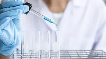 Professionnel maniant une pipette au dessus de tubes à essais