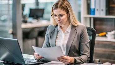 Professionnel(le) gérant des dossiers clients sur écran, ambiance administrative 