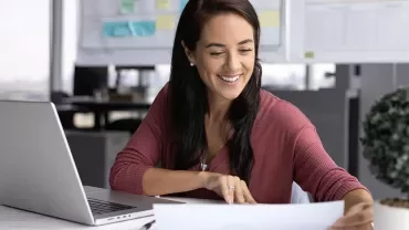 Femme souriante travaillant devant un ordinateur 