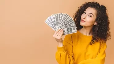 Femme tenant plusieurs billets de banque dans la main