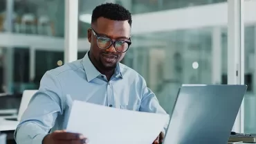Homme réfléchissant devant un ordinateur