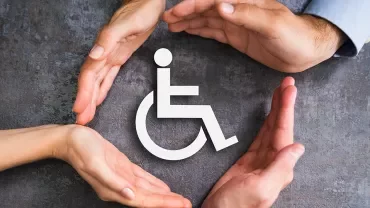 Cigle du handicap entouré de mains bienveillantes