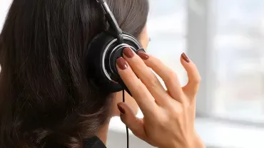 Femme de dos passant un appel téléphonique sur un casque audio