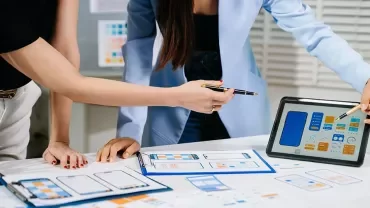 Designer devant une tablette graphique ou écran avec maquettes d'interface / ambiance créative