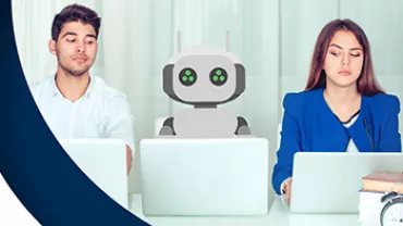 Deux personnes et un robot assis à une table avec des ordinateurs portables.