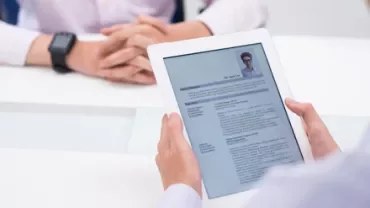 Entretien d'embauche avec un document sur tablette.
