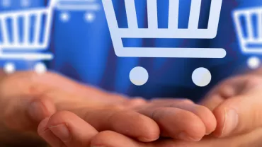 Mains ouvertes tenant des icônes de chariot d'achat.