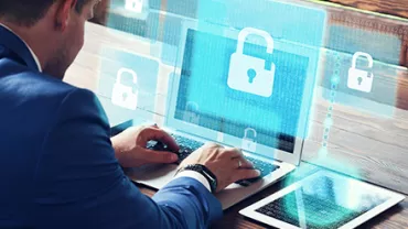 Personne utilisant un ordinateur portable avec des icônes de sécurité sur l'écran.
