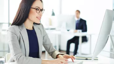 Personne travaillant à un ordinateur dans un bureau moderne.