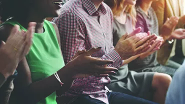 Groupe de personnes applaudissant lors d'un événement.