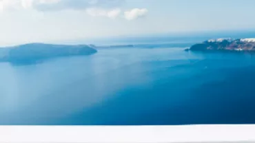 Vue panoramique de la mer avec ciel clair et îles à l'horizon.