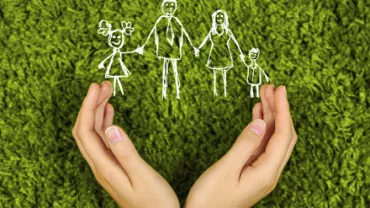 Dessins de famille au-dessus de mains ouvertes sur fond vert.