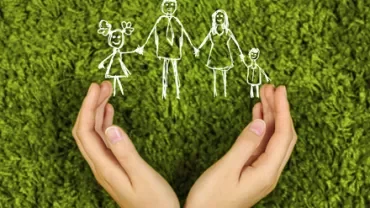 Dessins de famille au-dessus de mains ouvertes sur fond vert.