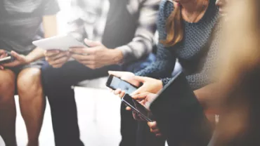 Groupe de personnes utilisant des appareils numériques.