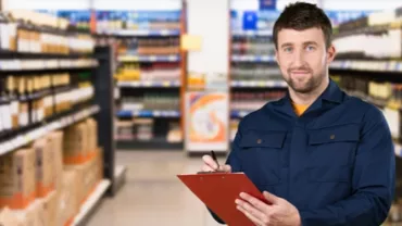 Personne tenant un clipboard dans une allée de supermarché.