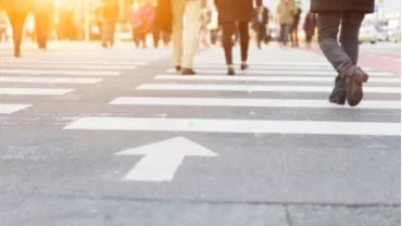Des personnes traversant un passage piétons en ville.
