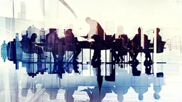 Silhouettes de personnes en réunion autour d'une table.