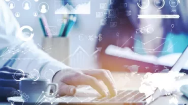 Personne utilisant un ordinateur portable avec des graphiques d'affaires en superposition.
