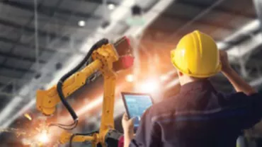 Travailleur vérifiant une machine automatisée dans une usine.