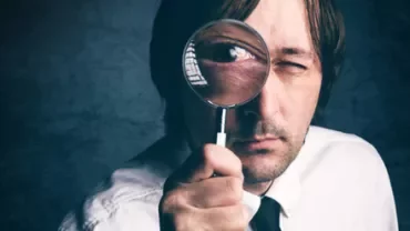 Personne regardant à travers une loupe.