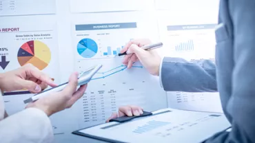 Discussion autour de graphiques financiers dans un bureau.