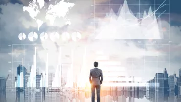 Une personne debout devant des graphiques financiers et un horizon urbain.