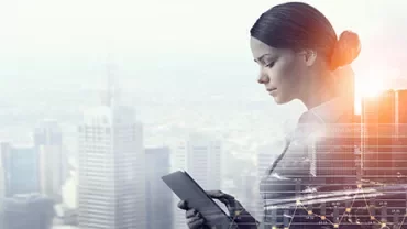 Personne regardant une tablette numérique, avec une ville en arrière-plan.